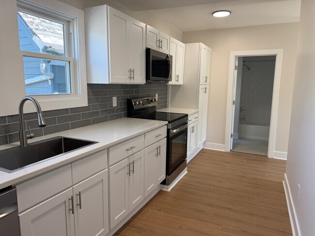 Cocina completa con armarios de cierre suave y encimeras de cuarzo. - 202 Vermont St