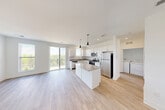 Located at 2501 Avant Ave in Ann Arbor, Michigan, this thoughtfully designed 2-bedroom, 2-bathroom residence offers a clean, modern aesthetic throughout its single-floor layout. The open-concept living and kitchen area serves as the heart of the home, featuring light hardwood-style flooring, crisp white cabinetry, granite countertops, and a central island illuminated by stylish pendant lighting. Stainless steel appliances — including a refrigerator, range, microwave, and dishwasher — complete the well-appointed kitchen. A sliding glass door leads to a private balcony overlooking lush greenery, flooding the living area with natural light. An in-unit washer and dryer provide added convenience. The spacious primary bedroom offers generous square footage with carpet flooring, while the second bedroom also features soft carpet and a large window with outdoor views. Both bathrooms are finished with granite-topped vanities and hardwood-style flooring; the primary bath includes a glass-enclosed shower. Throughout the residence, neutral white walls and consistent finishes create a bright, cohesive atmosphere. A dedicated closet adds practical storage to this well-organized, move-in-ready home.