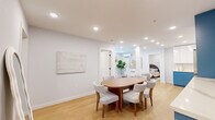 This well-appointed 3-bedroom, 2-bathroom unit at 55 Tunxis Ave in Bloomfield, CT offers a thoughtfully designed single-floor layout with a clean, modern aesthetic. The open-concept living area features light hardwood flooring, recessed lighting, and a wall-mounted mini-split system, creating a bright and comfortable atmosphere. The kitchen stands out with bold two-tone cabinetry — vibrant blue lower cabinets paired with white upper cabinets — complemented by stainless steel appliances, a subway tile backsplash, and an in-unit washer and dryer. The dining area flows seamlessly from the kitchen and living room, offering a cohesive space ideal for entertaining. The living room includes a structural column accent and natural light from a street-facing window. The primary bedroom features a closet with double doors and recessed lighting, while additional bedrooms are well-proportioned with natural light. Both bathrooms are finished with large-format marble-style wall tiles and dark matte black fixtures; one includes a soaking tub with shower combination, while the other features an open walk-in shower. The unit's neutral white walls and warm wood flooring tie the entire space together in a polished, contemporary style.