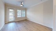 Located at 2200 Pooler Parkway in Pooler, Georgia, this thoughtfully designed one-bedroom, one-bathroom residence offers a comfortable and modern living experience across a single floor. Light hardwood flooring runs throughout the space, complementing the neutral, warm-toned walls that create a bright and inviting atmosphere.

The kitchen serves as a standout centerpiece, featuring a large island with dark granite countertops, a two-toned cabinet design combining crisp white upper cabinets with natural wood lower cabinets, a marble-style tile backsplash, and a full suite of stainless steel appliances. Pendant lighting above the island adds a contemporary touch, while recessed lighting ensures the space is well-lit.

The bedroom is generously proportioned, benefiting from large windows that invite natural light and offer outdoor views of surrounding greenery. A ceiling fan adds comfort, and crown molding provides a refined finish. The adjacent walk-in closet is outfitted with multi-tiered wire shelving and basket storage, maximizing organizational capacity.

The bathroom features a warm wood vanity with a white countertop, a framed mirror, and direct access to the walk-in closet. A private balcony extends the living space outdoors. Crown molding and clean white trim throughout lend the home a polished, cohesive character.