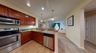 Located at 431 El Camino Real in Santa Clara, California, this single-floor residence offers a thoughtfully designed layout with a seamless blend of functionality and style. The open-concept kitchen is a standout feature, showcasing rich cherry wood cabinetry, granite countertops, stainless steel appliances including a refrigerator, range, microwave, and dishwasher, and hardwood-style flooring. A peninsula with bar seating provides a convenient casual dining option and creates a natural transition into the carpeted living area. The living room is bright and welcoming, benefiting from natural light through large windows and offering generous space for relaxation and entertaining. The bedrooms are comfortably sized with plush carpeting, warm neutral tones, and ample room for furnishings. The bathroom is finished with tile flooring, a white vanity with storage, and a full shower-tub combination. Throughout the residence, recessed and pendant lighting provide layered illumination, while neutral wall tones create a clean, versatile backdrop. The overall ambiance is modern and comfortable, making this Santa Clara residence a practical and attractive living space.