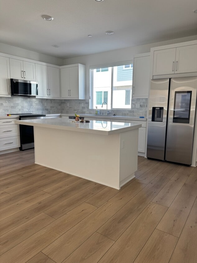 Cocina. Encimera de cuarzo con electrodomésticos Samsung nuevos, protector contra salpicaduras mejorado y piso de vinilo de lujo. - 14350 Savannah Ct