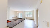 Located at 365 Lehigh Ave in Perth Amboy, NJ, this single-floor residence offers two bedrooms and two bathrooms within a thoughtfully laid-out floor plan. The living and dining area features light hardwood-style flooring and is illuminated by a classic chandelier, with a sliding glass door that opens to the outdoors and a large window fitted with vertical blinds, allowing ample natural light to fill the space. The kitchen is well-appointed with warm honey-toned cabinetry, dark granite countertops, stainless steel appliances including a gas range, microwave, and refrigerator, and tile flooring for easy maintenance. Both bedrooms are carpeted and bright, each featuring windows with vertical blinds that frame outdoor greenery. The primary bedroom includes access to a dedicated closet outfitted with wire shelving for organized storage. The two bathrooms offer distinct configurations — one features a soaking tub with a wood-toned vanity and tile flooring, while the other includes a glass-enclosed shower stall with white tile surround. Two hallways connect the rooms efficiently, contributing to the home's functional flow. The overall aesthetic is clean and neutral, presenting a versatile canvas throughout.