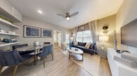 This thoughtfully designed 1-bedroom, 1-bathroom unit offers a cohesive and stylish living experience across a single floor. The open-concept main area seamlessly integrates the living room, dining room, and kitchen, creating an efficient yet comfortable layout. The living room features light wood-look flooring, a ceiling fan, and a large window dressed with floor-to-ceiling curtains that invite abundant natural light and outdoor views. The kitchen is well-equipped with gray cabinetry, granite countertops, a herringbone tile backsplash, and stainless steel appliances, including a refrigerator, range, and dishwasher. The adjacent dining area includes built-in shelving, providing both functional storage and display space. The bedroom is carpeted for comfort, features vaulted ceilings, a walk-in closet, and a window with outdoor views, offering a serene retreat. The bathroom is finished with granite countertops, gray cabinetry, wood-look flooring, and a full tub-shower combination with white tile surround. A consistent neutral color palette with blue accent tones ties the entire space together, conveying a modern and inviting ambiance throughout.