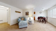 Located at 49 Arborwood Crescent in Rochester, NY, this one-bedroom, one-bathroom residence offers a thoughtfully arranged single-floor layout that maximizes its cozy footprint. The living room features soft wall-to-wall carpeting, a textured ceiling, and a welcoming entryway with a classic wood front door and window with blinds that allow for natural light. It connects seamlessly to the dining area, which is brightened by a large window and outfitted with a ceiling fan overhead. The kitchen is efficiently designed with warm wood cabinetry, a tile floor, a double-basin sink, and standard appliances including a range and ample counter space. The bedroom is a comfortable retreat, carpeted throughout, with a window for natural light and a large double-door closet providing generous storage. The bathroom features classic white tile wainscoting, mosaic tile flooring, and a shower-tub combination. Two hallways connect the rooms smoothly, contributing to a functional flow throughout the home. The overall ambiance is clean, neutral, and practical, making this residence a well-suited space for comfortable everyday living in Rochester, NY.