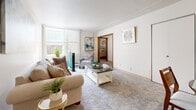 Located at 2220 W Layton Ave in Milwaukee, WI, this efficient one-bedroom, one-bathroom unit offers a well-planned single-floor layout. The living room is bright and welcoming, with large windows dressed in vertical blinds that allow generous natural light to fill the carpeted space. The room offers comfortable dimensions for everyday living and opens directly toward the bedroom, creating a seamless flow throughout the unit. The kitchen features warm oak cabinetry with ample upper and lower storage, neutral laminate countertops in an L-shaped configuration, a stainless steel sink, and a white range, all set atop easy-to-maintain tile flooring. The bedroom is a comfortably sized retreat with plush carpeting, natural light from a window with vertical blinds, and a closet with a classic wood-panel door. The bathroom includes a full tub and shower combo with tiled surround, a toilet, and a vanity, offering a clean and functional design. A hallway connects the rooms efficiently, completing the thoughtful layout of this compact yet comfortable Milwaukee residence.