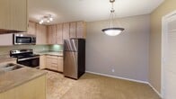 Located at 4631 Old Cheney Rd in Lincoln, Nebraska, this single-floor unit presents a practical and well-organized layout designed for comfortable everyday living. The living area features neutral-toned walls, plush wall-to-wall carpeting, and a large sliding glass door fitted with vertical blinds, allowing natural light to filter in while providing access to the outdoors. A textured ceiling runs throughout the main living spaces, lending a consistent architectural character.

The kitchen is efficiently arranged in a U-shaped configuration, featuring light wood cabinetry that extends to the ceiling for ample storage, laminate countertops, and stainless steel appliances including a refrigerator, range with microwave above, and a sink. Tile flooring grounds the kitchen area, which opens toward a dining space illuminated by a pendant light fixture and track lighting, creating a smooth transition between cooking and dining areas.

The bedrooms are carpeted and generously sized, with warm neutral walls and flush-mount ceiling fixtures. At least one bedroom includes a walk-in closet with built-in shelving. Additional bedrooms feature windows with blinds for natural light and privacy.

The bathroom is equipped with a tub-shower combination, tile flooring, a vanity with sink, and notably includes space for in-unit laundry. Overall, the unit maintains a clean, functional aesthetic throughout.