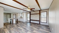 Located at 606 S 9th St in Ogden, Kansas, this single-story home offers four bedrooms and three bathrooms across a well-organized floor plan. The living area immediately impresses with its exposed dark wood ceiling beams, a ceiling fan, rustic shiplap accent wall, and wide-plank wood-look flooring that lends warmth and character throughout the main living spaces. Natural light filters in through multiple windows fitted with blinds, enhancing the open feel of the room.

The kitchen is a functional centerpiece of the home, featuring white shaker-style cabinetry, a stainless steel range hood, black appliances including a refrigerator and range, a textured tile backsplash, and a large island with a stone-look countertop and integrated sink — ideal for both cooking and casual dining. Recessed lighting illuminates the space efficiently.

The four bedrooms are carpeted and well-proportioned, each with windows that bring in natural light. The primary bedroom is generously sized and includes its own access point. The three bathrooms offer a mix of configurations, including a walk-in glass-door shower with wood-look flooring and a separate tub-shower combo, each finished with white cabinetry and stone-look countertops. Additional spaces include a hallway, entrance, and a closet, rounding out this practical and stylish home.