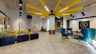Located in the heart of Orlando, this dynamic single-floor commercial space makes an immediate impression with its bold, contemporary design. The expansive lobby welcomes visitors through large glass entry doors that flood the polished concrete floors with natural light. A dramatic sunburst ceiling installation — featuring bold yellow radiating beams centered on a cylindrical column with warm wood paneling — serves as the defining architectural centerpiece of the space.

The interior palette of teal, mustard yellow, and warm neutrals is carried throughout, creating a cohesive and energetic atmosphere. Stylish mid-century modern seating arrangements, including teal wingback and pod chairs with vibrant yellow accent pillows, offer inviting areas for lounging and conversation. A lounge zone features a teal sofa and yellow armchairs beneath abstract artwork, adding an artistic touch.

A chic counter area with geometric black-and-white tile paneling, bar-height seating, and an olive-green accent wall with circular mirrors provides a functional yet design-forward service point. Private glass-walled offices or meeting rooms line one wall, above which a large-scale abstract mural in teal and yellow commands attention. An exposed industrial ceiling with visible ductwork and pendant lighting adds an urban, loft-like quality, balancing the refined furnishings with raw architectural character.