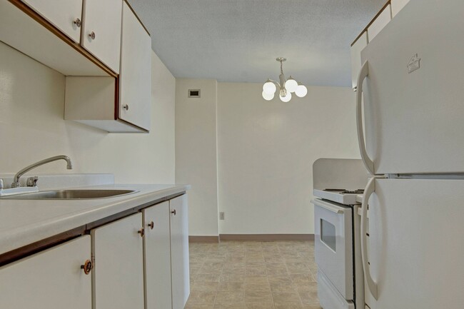 A kitchen with white appliances and white cabinetry - Marquis Towers