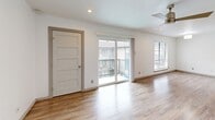 Located at 2800 Douglas Ave in Dallas's vibrant Oak Lawn neighborhood, this one-bedroom, one-bathroom residence offers a well-designed single-floor layout with a clean, modern aesthetic throughout. Wood-look flooring flows seamlessly across the living areas, complemented by crisp white walls and recessed lighting that create a bright, airy atmosphere.

The open kitchen is a standout feature, boasting rich dark granite countertops, white cabinetry with black hardware, a mosaic tile backsplash, and a full suite of stainless steel appliances including a refrigerator, electric range, built-in microwave, and dishwasher. Industrial-style track lighting adds a contemporary touch overhead. A peninsula counter connects the kitchen to the living area, enhancing the open-concept feel.

The living room is spacious and sun-filled, featuring wood-look flooring, a modern ceiling fan, and sliding glass doors that open to a private balcony with outdoor views. A large window further fills the space with natural light.

The bedroom is a comfortable retreat with wood-look flooring, a large window overlooking the surroundings, and a ceiling fan. The bathroom features floor-to-ceiling marble-style tile surrounding a soaking tub, wood-tone floor tile, a white vanity, and dark granite countertops, offering a polished, spa-like finish.