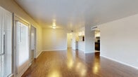 This single-story, 3-bedroom, 3-bathroom home offers a practical and comfortable layout designed for everyday living. The combined living and dining area serves as the heart of the home, featuring rich wood-look hardwood flooring, neutral-toned walls, and large windows that invite natural light and provide outdoor views. The open sightline to the kitchen enhances the sense of space throughout the main living area.

The kitchen is equipped with white cabinetry, speckled laminate countertops, tile flooring, and black appliances including a full-size refrigerator. A pass-through opening connects the kitchen to the living and dining space, improving flow and functionality.

Each of the three bedrooms is fitted with plush carpeting and ceiling fans with light fixtures. The primary bedroom is generously sized and features two closets and direct access to an en-suite bathroom. The additional bedrooms also offer closet storage. The three bathrooms are consistently finished with white vanities, speckled countertops, and tub-shower combinations with tile surrounds.

A dedicated laundry room with washer and dryer hookups adds everyday convenience. A central hallway connects all rooms efficiently. Throughout the home, a clean, neutral color palette creates a bright and move-in-ready atmosphere.