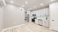 Located at 90 N Swan St in Albany, NY, this thoughtfully designed single-floor unit offers a clean, modern aesthetic with every detail carefully considered. The open layout maximizes the available space, with light wood-tone vinyl plank flooring running throughout, creating a bright and cohesive feel.

The kitchen is the centerpiece of the unit, featuring floor-to-ceiling white shaker cabinetry with black hardware, a marble-look quartz countertop, and a glass tile backsplash. A full suite of stainless steel appliances — including a French door refrigerator, electric range, built-in microwave, and dishwasher — provides full functionality. A deep undermount sink with a matte black spring-neck faucet adds a refined touch. In-unit washer and dryer are conveniently positioned adjacent to the kitchen area.

A separate bedroom area includes a wall-mounted mini-split HVAC unit, offering independent climate control. Recessed lighting throughout ensures consistent, modern illumination.

The bathroom is elegantly appointed with large-format stone-look floor tile, floor-to-ceiling marble-veined wall tile, a warm walnut vanity with white countertop, a mirrored medicine cabinet, and sophisticated gold and black fixtures. A walk-in shower completes the space. This unit combines contemporary design with practical amenities in a compact, well-appointed layout.