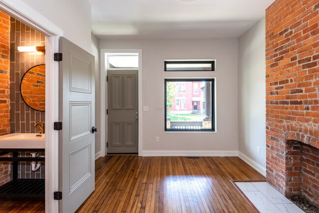 120 year-old refinished hardwood flooring and exposed brick. On the left, a stylish powder room. - 598 S Ohio Ave