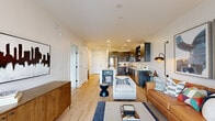 Located at 200 Nerem St NW in Atlanta, GA, this thoughtfully designed one-bedroom, one-bathroom residence offers a streamlined, modern living experience across a single floor. The open-concept layout connects the living, dining, and kitchen areas, creating a cohesive and functional space bathed in natural light.

The kitchen is a standout feature, showcasing dark wood cabinetry, a classic white subway tile backsplash, stainless steel appliances — including a refrigerator, range, and microwave — and a white quartz peninsula with seating, ideal for casual dining or entertaining. Light hardwood flooring flows throughout the main living areas, contributing to a warm, contemporary aesthetic.

The living room is bright and welcoming, with large windows and a glass door that open to a private balcony, offering pleasant outdoor views. The bedroom features plush carpeting, a generous window with balcony views, and a ceiling fan, providing a comfortable and serene retreat.

The bathroom is finished with large-format light tile flooring, a glass-enclosed walk-in shower with floor-to-ceiling tile surround, and a vanity with dark cabinetry. Additional highlights include a dedicated closet, hallway, and recessed lighting throughout, combining practicality with polished, modern design.