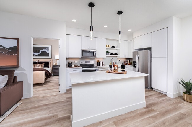 Kitchen with prep island and light wood style flooring - Marlowe South Las Vegas