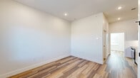 Located at 220 N Walton Blvd in Bentonville, Arkansas, this thoughtfully designed one-bedroom, one-bathroom unit delivers a clean, modern aesthetic across its single-floor layout. Wood-look plank flooring flows seamlessly throughout, complementing the crisp white walls and recessed lighting that create a bright, airy atmosphere.

The galley-style kitchen is a standout feature, outfitted with flat-front cabinetry in a warm natural wood tone, dark quartz countertops, a subway tile backsplash, and a full suite of stainless steel appliances including an electric range, over-the-range microwave, and refrigerator. A sleek single-basin sink with a matte black faucet adds a contemporary finishing touch.

The bedroom is a comfortable and well-proportioned space with clean white walls and the same warm flooring, offering a calm and versatile retreat. A large window allows natural light to fill the room, which also features a built-in wardrobe cabinet and a stacked in-unit washer and dryer — a highly practical inclusion.

The bathroom continues the modern design language with a tiled tub-shower combination, matte black fixtures and hardware, and a vanity with matching wood cabinetry and dark countertop. The overall design of the unit is cohesive, minimal, and move-in ready, making it an efficient and stylish option in the heart of Bentonville.