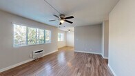 Located at 13312 Community Road in Poway, CA, this single-story 2-bedroom, 2-bathroom home offers a practical and well-maintained layout. The open living room welcomes you with warm wood-look laminate flooring, a ceiling fan with light fixture, and windows fitted with horizontal blinds that allow natural light to filter in. A wall-mounted AC unit provides climate control. The galley-style kitchen is efficiently designed with white cabinetry extending to the ceiling, quartz-style countertops, a stainless steel sink, and white appliances including a gas range, refrigerator, microwave, and dishwasher — all lit by a flush-mount ceiling fixture. Both bedrooms feature ceiling fans; one is finished with the same wood-look flooring, while the primary bedroom offers plush carpeting and a textured ceiling. Each bedroom includes a window for natural light. The two bathrooms are clean and functional, each featuring white vanity cabinetry with brushed nickel hardware, quartz-style countertops, large mirrors, and wood-look flooring. One bathroom includes a full shower/tub combo. A dedicated closet provides additional storage. The home's neutral color palette and consistent finishes create a cohesive, move-in-ready atmosphere throughout.
