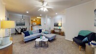 Located at 111 Springview Ln in Summerville, SC, this single-floor residence offers a comfortable and well-designed layout with a cohesive, neutral color palette throughout. The living room is generously sized, featuring plush wall-to-wall carpeting, crown molding, recessed lighting, and a ceiling fan. A glass-paned door allows natural light to filter in, while open sight lines connect seamlessly to the dining area and kitchen. The dining space is defined by a pendant light fixture and sits adjacent to the kitchen, which is appointed with warm wood cabinetry, dark granite-style countertops, and white appliances, including a dishwasher. A hallway from the kitchen leads to a dedicated laundry area. The residence includes multiple bedrooms, each carpeted and filled with natural light from well-positioned windows with curtains. The primary bedroom features access to an en-suite bathroom. Both bathrooms are finished with tile flooring and include a full tub-and-shower combination with built-in shelving. The overall ambiance is bright, clean, and move-in ready, with a layout that balances open communal spaces and private retreats, making it a practical and inviting home in Summerville.