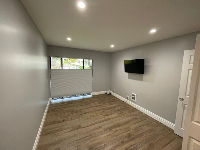 Bedroom with blackout shades and mounted TV - 1817 California St
