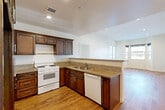 Located at 14105 Chadron Ave in Hawthorne, CA, this well-appointed single-floor, one-bedroom, two-bathroom residence offers a thoughtfully designed layout with comfort and functionality in mind. Warm hardwood-style flooring flows consistently throughout the home, creating a cohesive and inviting atmosphere.

The open-concept kitchen and living area forms the heart of the home. The kitchen is outfitted with rich dark-wood cabinetry, granite countertops, a gas range, dishwasher, stainless steel refrigerator, and a peninsula that seamlessly connects to the living space. Recessed lighting illuminates the area, and the open sightlines to the living room enhance the sense of spaciousness.

The bedroom is a comfortable retreat featuring direct access to a private balcony through sliding glass doors, allowing for natural light and outdoor views of the neighborhood. Three closets provide abundant storage throughout the unit, including generously sized closets with full hanging rods.

Both bathrooms are finished with granite-topped dark-wood vanities, large framed mirrors, and tile flooring. One bathroom features a tub-shower combination with a glass sliding door. Clean white walls and neutral tones throughout the home contribute to a bright, move-in-ready feel that is both practical and welcoming.