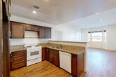 Located at 14105 Chadron Ave in Hawthorne, CA, this well-appointed single-floor, one-bedroom, two-bathroom residence offers a thoughtfully designed layout with comfort and functionality in mind. Warm hardwood-style flooring flows consistently throughout the home, creating a cohesive and inviting atmosphere.

The open-concept kitchen and living area forms the heart of the home. The kitchen is outfitted with rich dark-wood cabinetry, granite countertops, a gas range, dishwasher, stainless steel refrigerator, and a peninsula that seamlessly connects to the living space. Recessed lighting illuminates the area, and the open sightlines to the living room enhance the sense of spaciousness.

The bedroom is a comfortable retreat featuring direct access to a private balcony through sliding glass doors, allowing for natural light and outdoor views of the neighborhood. Three closets provide abundant storage throughout the unit, including generously sized closets with full hanging rods.

Both bathrooms are finished with granite-topped dark-wood vanities, large framed mirrors, and tile flooring. One bathroom features a tub-shower combination with a glass sliding door. Clean white walls and neutral tones throughout the home contribute to a bright, move-in-ready feel that is both practical and welcoming.