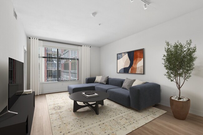 Sala de estar renovada del Paquete II con piso de superficie dura. - Avalon at Cahill Park