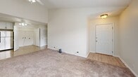 Located at 307 Towne Dr in Elizabethtown, KY, this well-appointed apartment offers 2 bedrooms and 2 bathrooms across a single floor. The kitchen is a standout feature, equipped with stainless steel appliances including a refrigerator, range, microwave, and dishwasher, complemented by crisp white cabinetry and light wood-style flooring that extends into the entry area. A ceiling fan adds comfort to the open kitchen and hallway space. The living room is generously sized with plush carpeting, and benefits from abundant natural light through large windows and a glass-paned door that opens to the outdoors. Both bedrooms are carpeted and bright, each featuring large windows that frame views of the surrounding neighborhood. The primary bedroom offers comfortable proportions with its own closet. The two bathrooms are finished with white vanities, marble-style countertops, brushed gold faucets, large mirrors, and shower-tub combinations, providing a clean and modern aesthetic. Additional closets throughout the unit offer practical storage. Neutral wall tones and consistent finishes create a cohesive, move-in-ready feel throughout the entire space.