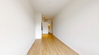 Located on Sherbrooke Street West in Montréal's vibrant NDG/Westmount border area, this studio offers a clean, modern design with a highly functional open-concept layout. The main living area is bathed in natural light from a large window framing views of the Montréal skyline, with crisp white walls and light wood laminate flooring running throughout, creating a bright and cohesive aesthetic. A wall-mounted mini-split unit provides efficient climate control year-round, complemented by baseboard heating. The kitchen is neatly integrated into the space and features white cabinetry, a dark tile backsplash, and stainless steel appliances including a range, lending a contemporary contrast to the otherwise all-white palette. Recessed track lighting highlights the kitchen area. The bathroom is finished with full white square tile on both the floors and walls, and includes a sleek walk-in shower enclosed by sliding glass doors with chrome hardware, along with a standard toilet. The overall ambiance is minimalist and move-in ready, with a well-considered use of space that maximizes functionality within a compact footprint — ideal for a single occupant seeking a modern urban residence in a prime Montréal location.