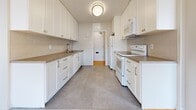 Located at 495 Errol Rd W in Sarnia, Ontario, this 2-bedroom, 1-bathroom unit offers a practical and comfortable single-floor layout. Warm parquet hardwood flooring flows consistently throughout the living areas and bedrooms, adding a classic character to the space. The living room is bright and open, with large windows that invite natural light and offer pleasant outdoor views of mature trees.

The galley-style kitchen is well-appointed with white shaker cabinetry, taupe laminate countertops, tile flooring, and white appliances including a refrigerator, electric range, and built-in microwave. Ample upper and lower cabinet storage lines both walls, maximizing functionality.

The generously sized primary bedroom features a wide window with outdoor views, while the second bedroom also benefits from natural light through its own window. Both bedrooms are finished with the same warm parquet flooring. A double-door closet in one bedroom provides useful storage.

The bathroom is clean and neutral, featuring a white vanity with storage cabinetry, a tub-shower combination, tile flooring, and windows that allow natural ventilation. A private balcony accessible from the living area rounds out the unit, offering outdoor space. A hallway connects the rooms cohesively throughout.
