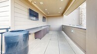 Located at 821 W Lake St in Fort Collins, Colorado, this rooftop terrace offers a well-appointed outdoor gathering space with panoramic views of the Rocky Mountains and the surrounding cityscape. The open-air deck is finished with large-format light tile flooring throughout, creating a clean and cohesive aesthetic across the entire level.

The terrace is thoughtfully divided into multiple functional zones. A central lounge area features wicker sectional sofas and coffee tables, providing a comfortable setting for relaxed gatherings. A striking stone-clad fireplace column anchors one section of the deck, adding a rustic architectural focal point and a source of warmth for cooler evenings.

A covered outdoor pavilion houses a built-in bar area equipped with granite countertops, dark cabinetry, a utility sink, and multiple wall-mounted flat-screen televisions — ideal for entertaining. Bar-height seating lines the counter, extending the social atmosphere under the sheltered structure.

Additional high-top dining tables and chairs are distributed across the open portions of the deck, accommodating a variety of seating preferences. The terrace is enclosed by a low perimeter railing that preserves the expansive sightlines to the mountains and the mature tree canopy below, while the open sky above ensures abundant natural light throughout the day.