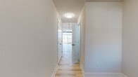 This well-designed two-floor residence combines modern finishes with a clean, neutral aesthetic throughout. The main level opens into a spacious living and dining area adorned with light hardwood flooring and a stylish chandelier that anchors the room. The kitchen is thoughtfully appointed with white shaker-style cabinetry extending to the ceiling, dark quartz countertops, stainless steel appliances including a French door refrigerator and range, and a pendant-lit island that serves as a natural gathering point. A half bathroom on the main level adds everyday convenience.

A light-filled hallway with flush-mount ceiling lighting connects the upper level's rooms, all featuring soft neutral walls and bright white trim. Bedrooms offer generous proportions, with some showcasing plush carpeting and ceiling fans, while others feature the same warm hardwood flooring found below. Natural light pours in through double-hung windows fitted with clean white blinds.

The bathrooms are finished to a high standard. One features a frameless neo-angle glass shower enclosure, dark espresso vanity cabinetry, and stone-toned countertops, while another offers a full tiled tub surround and matching vanity. Throughout, the space maintains a cohesive, move-in-ready character defined by clean lines and quality craftsmanship.