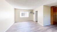 Located at 7050 Jordan Ave in the Canoga Park neighborhood of Los Angeles, this efficiently designed single-floor unit makes smart use of its intimate footprint. The open-plan living and dining area serves as the heart of the space, finished with light wood-look laminate flooring that extends throughout. A ceiling fan and vertical blind-covered window provide both comfort and natural light, while a textured ceiling adds a classic residential character to the room.

The kitchen is thoughtfully appointed with warm-toned wood cabinetry offering generous storage above and below the counter. A gas range with an overhead microwave and tile countertops complete the functional cooking space, which opens conveniently toward the main living area.

Two bathrooms serve the unit, with the primary bathroom featuring a white vanity with a marble-style countertop, an undermount sink, and a large wall mirror framed by overhead lighting. The clean, neutral palette of cream and white tones creates a bright and airy feel. The second bathroom is equally clean and minimal in design.

A dedicated closet provides additional storage. Throughout the unit, light-toned walls and consistent flooring create a cohesive, easy-to-style aesthetic. The unit's layout and finishes offer a practical and comfortable living environment in a well-connected Los Angeles neighborhood.