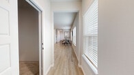 This two-story home offers a well-planned layout across two floors, providing ample space for comfortable living. The main floor is the larger of the two levels, featuring open, light-filled areas with light wood-look flooring that flows seamlessly throughout. The kitchen is a standout space, appointed with white shaker cabinetry, granite countertops, a subway tile backsplash, and stainless steel appliances, combining both style and functionality. Wide hallways with large, white-shuttered windows allow abundant natural light to permeate the interior, creating a bright and welcoming atmosphere. The second floor continues the same cohesive design aesthetic with additional bedrooms and bathrooms. The five bedrooms are well-proportioned, with the primary bedroom offering a comfortable retreat complemented by a dedicated closet featuring built-in shelving and hanging rods. The eight bathrooms are finished with clean, neutral tones and wood-look flooring. A dedicated attached garage with an automatic opener provides secure parking and additional storage. Throughout the home, a consistent neutral color palette, clean lines, ceiling fans, and carefully placed windows contribute to a modern, airy ambiance suited for everyday living.