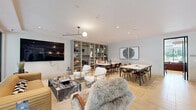 Located at 8377 Blackburn Ave in the heart of Los Angeles, this thoughtfully designed single-floor space offers a sophisticated blend of modern aesthetics and functional living. Light-toned hardwood flooring runs throughout, anchoring a cohesive and inviting atmosphere.

The living area is a standout, anchored by floor-to-ceiling glass walls that frame lush outdoor greenery and bathe the room in abundant natural light. A wall-mounted flat-screen TV, a curated built-in shelving unit, and an eclectic mix of seating — including a plush sectional, a ribbed mustard sofa, gold-framed accent chairs, and a sculptural shag armchair — create a layered, design-forward lounge environment. A striking marble-top coffee table grounds the space with an air of elegance.

The dining area accommodates generous group seating around a large white dining table, complemented by contemporary artwork on the walls and track lighting overhead. Tucked alongside the dining space are charming arched alcoves finished with patterned wallpaper and built-in banquette seating — offering intimate settings ideal for smaller gatherings or focused conversations.

A private meeting room with its own conference table and curated wall art provides a more enclosed option within the overall layout. Throughout the space, recessed lighting, pendant fixtures, and carefully selected art pieces contribute to a polished, gallery-like ambiance.