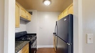 Located at 110 North 17th Street in St. Louis, Missouri, this efficiently designed single-floor unit offers a thoughtful layout across a compact footprint. The space includes a living room, kitchen, bathroom, and two hallways that connect the rooms seamlessly.

The living room is a bright, open area highlighted by rich hardwood flooring and neutral-toned walls. Large windows allow natural light to fill the space while offering views of the surrounding St. Louis cityscape. A built-in closet provides convenient storage, and the room connects directly to the hallway leading to the rest of the unit.

The kitchen is well-appointed with warm natural wood cabinetry, dark granite countertops with subtle mineral veining, and a gas range, offering both style and functionality. Upper cabinets provide ample storage space for a unit of this scale.

The bathroom features a clean, white aesthetic with tile flooring in a neutral stone pattern, a white vanity with an integrated countertop, a framed mirror, and overhead pendant lighting. The space is bright and efficiently organized.

Two hallways guide the flow between rooms, ensuring a logical and accessible layout throughout the unit. Overall, the space presents a practical and well-maintained interior suited for urban living in the heart of St. Louis.
