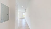 This thoughtfully designed one-bedroom, one-bathroom unit in Everett, MA offers a clean, modern aesthetic with a bright and airy atmosphere throughout. Light wood-tone flooring runs continuously across the entire floor plan, complementing the crisp white walls and creating a cohesive, contemporary feel.

The open kitchen and living area serves as the heart of the unit. The kitchen is outfitted with full stainless steel appliances, including a French door refrigerator, electric range, built-in microwave, and dishwasher. Two-tone cabinetry pairs glossy white upper cabinets with warm wood-finish lower cabinets, adding visual depth. Recessed lighting and a window allow natural light to fill the space.

The living area is generously proportioned and bathed in natural light from multiple large windows that frame views of surrounding greenery. A wall-mounted mini-split system provides efficient climate control.

The bedroom is a well-sized retreat featuring dual windows that overlook tree canopy views, filling the room with abundant daylight and a sense of calm.

The bathroom is clean and modern, featuring a glass-enclosed shower stall and light tile flooring. A dedicated closet provides practical storage. The unit's overall design prioritizes natural light, efficient use of space, and a minimalist, move-in-ready finish.