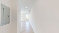 This thoughtfully designed one-bedroom, one-bathroom unit in Everett, MA offers a clean, modern aesthetic with a bright and airy atmosphere throughout. Light wood-tone flooring runs continuously across the entire floor plan, complementing the crisp white walls and creating a cohesive, contemporary feel.

The open kitchen and living area serves as the heart of the unit. The kitchen is outfitted with full stainless steel appliances, including a French door refrigerator, electric range, built-in microwave, and dishwasher. Two-tone cabinetry pairs glossy white upper cabinets with warm wood-finish lower cabinets, adding visual depth. Recessed lighting and a window allow natural light to fill the space.

The living area is generously proportioned and bathed in natural light from multiple large windows that frame views of surrounding greenery. A wall-mounted mini-split system provides efficient climate control.

The bedroom is a well-sized retreat featuring dual windows that overlook tree canopy views, filling the room with abundant daylight and a sense of calm.

The bathroom is clean and modern, featuring a glass-enclosed shower stall and light tile flooring. A dedicated closet provides practical storage. The unit's overall design prioritizes natural light, efficient use of space, and a minimalist, move-in-ready finish.