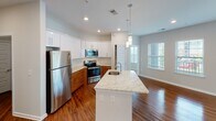 Located at 329 Broomsedge Trail in Chattanooga, Tennessee, this single-floor residence offers a well-designed layout with thoughtful finishes throughout. Rich hardwood flooring flows through the main living areas, complemented by neutral-toned walls and recessed lighting that keep the space feeling bright and welcoming.

The kitchen is a standout feature, showcasing granite countertops, a center island with an undermount sink, white upper cabinetry paired with warm wood-toned lower cabinets, and a full suite of stainless steel appliances. Pendant lighting over the island and natural light from adjacent windows enhance the open, airy feel of this space.

The bedrooms are generously sized, with plush carpet flooring and ceiling fans, and benefit from natural light through slatted blinds. The primary bedroom connects to a well-appointed en-suite bathroom featuring a wide granite-topped vanity with dual sinks, ample white cabinetry, and direct access to a spacious walk-in closet with built-in wire shelving. A second bathroom mirrors this refined aesthetic with granite counters and hardwood flooring.

A dedicated laundry room with full-size washer and dryer adds practical convenience. A hallway with a louvered door provides additional storage access. The overall design balances modern finishes with functional, comfortable living throughout.