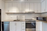 Located at 3445 Berkley St in Alexandria, VA, this well-designed 2-bedroom, 2-bathroom unit offers a thoughtfully laid-out single-floor plan with a generous amount of living space. The entrance opens into a bright, open-concept dining and living area, providing a versatile space for everyday living and entertaining. The modern kitchen is a standout feature, boasting white shaker-style cabinetry extending to the ceiling, gray quartz countertops, a white subway tile backsplash, and a full suite of stainless steel appliances including a refrigerator, dishwasher, and electric range. Rich wood-look flooring runs throughout the main living areas, adding warmth and continuity. Both bedrooms are carpeted and receive natural light through large windows with outdoor views of greenery. The primary bedroom offers a comfortable, well-proportioned retreat. The bathrooms feature light tile flooring, white vanities, and one is equipped with accessibility grab bars. A dedicated den provides flexible space for a home office or additional living area. Five closets throughout the unit ensure ample storage. In-unit laundry adds everyday convenience, completing this practical and modern residence.