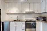 Located at 3445 Berkley St in Alexandria, VA, this well-designed 2-bedroom, 2-bathroom unit offers a thoughtfully laid-out single-floor plan with a generous amount of living space. The entrance opens into a bright, open-concept dining and living area, providing a versatile space for everyday living and entertaining. The modern kitchen is a standout feature, boasting white shaker-style cabinetry extending to the ceiling, gray quartz countertops, a white subway tile backsplash, and a full suite of stainless steel appliances including a refrigerator, dishwasher, and electric range. Rich wood-look flooring runs throughout the main living areas, adding warmth and continuity. Both bedrooms are carpeted and receive natural light through large windows with outdoor views of greenery. The primary bedroom offers a comfortable, well-proportioned retreat. The bathrooms feature light tile flooring, white vanities, and one is equipped with accessibility grab bars. A dedicated den provides flexible space for a home office or additional living area. Five closets throughout the unit ensure ample storage. In-unit laundry adds everyday convenience, completing this practical and modern residence.
