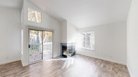 Located at 637 Stonebridge Way in Pleasant Hill, CA, this single-floor, 2-bedroom, 2-bathroom home offers a thoughtfully designed layout filled with natural light. The bright and airy living room is a standout, featuring soaring vaulted ceilings, light wood-style flooring, and a striking corner fireplace framed by large sliding glass doors and windows that look out onto a private balcony overlooking the tree-lined community grounds, including a playground area. The kitchen is well-appointed with white shaker cabinetry, gleaming quartz countertops, a peninsula with a stainless steel sink, and a full suite of stainless steel appliances. An adjacent dining room flows seamlessly from the kitchen, creating an open and functional living space. The generously sized primary bedroom features vaulted ceilings, a large window, and a built-in sliding-door closet. The second bedroom is equally comfortable, also offering wood-style flooring and a closet. Both bathrooms are clean and functional, with the full bath featuring a tub/shower combo and contemporary vanity. Additional highlights include a dedicated laundry area, utility room, four closets throughout, and a hallway connecting the space cohesively. The home's crisp white palette and modern finishes create a fresh, move-in-ready atmosphere.