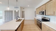 Located at 211 Gilroy Dr in Cordova, TN, this single-story, 2-bedroom, 2-bathroom home offers a thoughtfully designed open-concept layout with modern finishes throughout. Light hardwood-style flooring flows seamlessly across every room, creating a cohesive and airy aesthetic.

The kitchen serves as the heart of the home, featuring warm-toned cabinetry, quartz countertops, a subway tile backsplash, stainless steel appliances, and a central island with a double-basin sink and elegant pendant lighting. The kitchen opens directly into the spacious living area, which is brightened by a glass-panel door and ceiling fan.

Both bedrooms are well-proportioned and filled with natural light from large windows with blinds, each equipped with a ceiling fan for added comfort. The primary bedroom includes access to a walk-in closet outfitted with wire shelving for efficient storage organization.

The two bathrooms continue the home's clean, contemporary style. One features a tub-shower combination with large-format tile surround, a wood-toned vanity with a white countertop, and hardwood-style flooring. The consistent use of neutral tones and quality materials throughout the home creates a bright, welcoming atmosphere that is both functional and visually appealing.