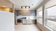 Located at 685 Kenilworth Terr NE in Washington, DC, this thoughtfully designed single-floor studio offers a clean, contemporary aesthetic throughout. Light-toned luxury vinyl plank flooring runs seamlessly across the entire unit, lending warmth and visual continuity to the open layout.

The kitchen is a standout feature, outfitted with two-tone cabinetry — charcoal upper cabinets paired with light wood lower cabinets — accented by matte black hardware. A classic white subway tile backsplash complements the light countertops, while stainless steel appliances, including a range, dishwasher, microwave, and full-size refrigerator, provide full functionality. Track lighting with black fixtures illuminates the space, and a large window allows abundant natural light and neighborhood views.

The living area is open and versatile, featuring neutral warm-toned walls and an interior clerestory window that borrows light from the kitchen, enhancing airflow and brightness throughout.

The full bathroom is designed with accessibility in mind, featuring matte black grab bars, a soaking tub with a handheld showerhead, large-format light tile flooring, and clean beige walls that create a calm, spa-like atmosphere. The unit's modern finishes and practical layout make it a well-appointed and functional living space.