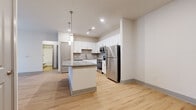 Located at 2272 Parkstone Dr in Indian Land, SC, this single-story, 3-bedroom, 2-bathroom home offers a well-organized and functional layout. The open-concept kitchen and living area serves as the heart of the home, showcasing white shaker-style cabinetry, a subway tile backsplash, granite countertops, a central kitchen island with pendant lighting, and a full suite of stainless steel appliances including a refrigerator, range, and over-the-range microwave. Light wood-tone flooring flows throughout the main living areas, creating a bright and cohesive aesthetic. The three bedrooms feature neutral carpet, soft wall tones, and grey-paneled doors, providing a calm and comfortable environment. The primary bedroom is a well-proportioned retreat with access to a shared hallway. The bathrooms are finished with white cabinetry, granite countertops, and wood-look flooring; one bathroom includes a double-sink vanity with a large mirror, while the other features a full tub/shower combo. A dedicated laundry room with side-by-side washer and dryer units and overhead wire shelving adds everyday convenience. A closet and hallway complete the thoughtfully arranged floor plan.