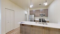 Located in Vancouver, WA, this single-floor, 2-bedroom, 2-bathroom residence offers a clean, modern aesthetic throughout. Light wood-style flooring flows consistently across all rooms, complementing the neutral, warm-toned walls and creating a bright, cohesive atmosphere.

The open-concept kitchen is a standout feature, boasting a generous peninsula with a white quartz countertop, an undermount sink, and warm wood cabinetry. Stainless steel appliances — including a refrigerator, gas range, and microwave — pair with pendant lighting above the peninsula to create a functional yet stylish cooking and dining space.

The living room is filled with natural light from large windows and a glass door that opens to the outdoors, offering pleasant exterior views. A wall-mounted mini-split unit provides efficient climate control.

The spacious primary bedroom features ample natural light and generous closet space. The second bedroom includes a large sliding-door closet and a window with neighborhood views. Both bedrooms are finished with the same light flooring found throughout the home.

Each of the two bathrooms is outfitted with a full tub/shower combo, brushed nickel fixtures, and light wood-style flooring, maintaining the consistent modern finish present across the entire residence.