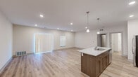 Located at 267 Seminole Rd in Norton Shores, Michigan, this single-story, one-bedroom, one-bathroom residence offers a thoughtfully designed layout with modern finishes throughout. The open-concept kitchen and living area serves as the heart of the home, highlighted by light-toned hardwood-style flooring, recessed lighting, and large vertical-blind windows that fill the space with natural light. The kitchen is outfitted with rich warm-toned cabinetry, granite-look countertops, stainless steel appliances — including a refrigerator, range, and microwave — and a center island with a sink and pendant lighting above, providing both functionality and a refined aesthetic. The living area flows seamlessly from the kitchen, offering a generous, open feel. The bedroom features plush carpeting, a window with vertical blinds, and access to a walk-in closet equipped with wire shelving and hanging rods for ample storage. The full bathroom includes a vanity with granite-look countertops, warm cabinetry matching the kitchen, a tub/shower combination, and hardwood-style flooring. A dedicated laundry area adds everyday convenience. Clean neutral walls and consistent finishes throughout create a cohesive, move-in-ready living environment.