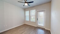 Located in Apopka, Florida, this well-appointed one-bedroom, one-bathroom residence offers a thoughtfully designed open-concept layout finished with warm wood-look flooring throughout. The kitchen serves as the centerpiece of the living area, boasting a large island with a white quartz countertop, dual pendant lights with glass shades, a stainless steel sink with a matte black faucet, and stainless steel appliances including a refrigerator with ice maker, range, microwave, and dishwasher. Two-tone cabinetry — crisp white uppers paired with gray lowers — and a herringbone tile backsplash add a modern, polished aesthetic. The open living area benefits from natural light through a large window and balcony door, complemented by a ceiling fan overhead. The bedroom is generously sized, featuring its own ceiling fan, wood-look flooring, and direct access to both the bathroom and a dedicated walk-in closet equipped with wire shelving for ample storage. The bathroom is finished with large-format tile in the walk-in shower, a frameless glass enclosure with matte black hardware, and wood-look flooring. A private balcony rounds out the space, providing an outdoor retreat.