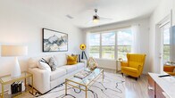 Located at 2130 Leather Fern Dr in Odessa, FL, this single-floor residence offers a thoughtfully designed open-concept layout with clean, contemporary finishes throughout. The living and dining areas are anchored by large windows that frame stunning water views, flooding the space with natural light and creating a bright, airy ambiance. A ceiling fan complements the well-lit interior, while wood-look flooring ties the common areas together seamlessly.

The modern kitchen is a standout feature, equipped with floor-to-ceiling flat-panel cabinetry in a warm taupe finish, stainless steel appliances including a range, microwave, dishwasher, and refrigerator, and a white quartz countertop island with bar seating — ideal for both meal prep and casual dining.

The bedroom is a serene retreat, carpeted for comfort and outfitted with a ceiling fan, natural window light, and access to a spacious walk-in closet with multi-tier wire shelving and hanging rods for generous storage. The bathroom is finished in a clean, minimalist style with a soaking tub, shower combo featuring marble-style tile surround, a floating vanity with white quartz countertop, and a large wall mirror. The overall design balances functionality with modern elegance throughout.