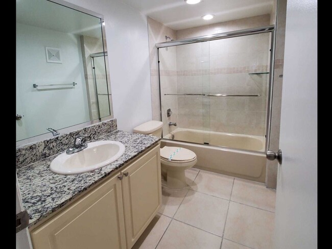 Bathrooms with Granite Countertops and Sliding Glass Tub Doors - Country Club Towers